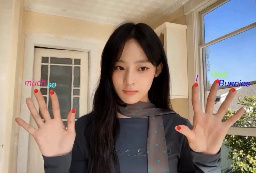 NewJeans anniversary social post showing Minji folding fingers