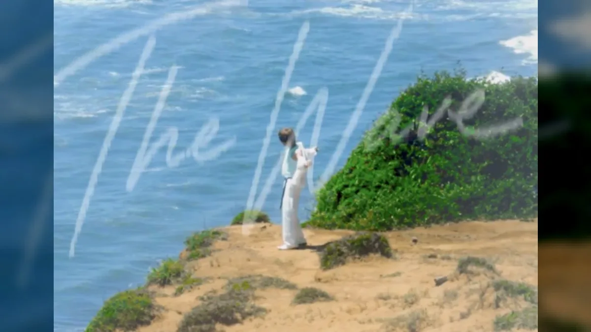 Kim Jae Joong standing on a seaside cliff feeling the ocean breeze