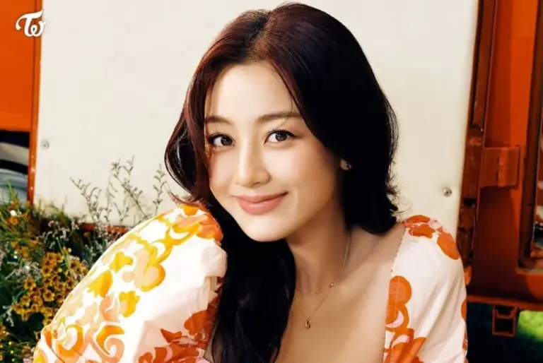 Jihyo performing on stage in a bright summer outfit waving to crowd