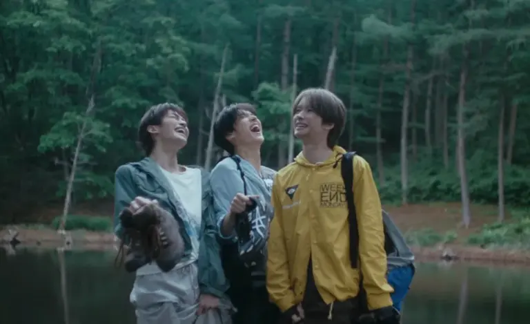 TWS members laughing and smearing mud in rain-soaked forest