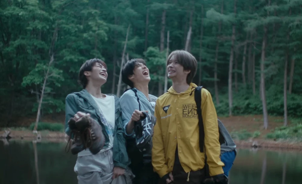 TWS members laughing and smearing mud in rain-soaked forest